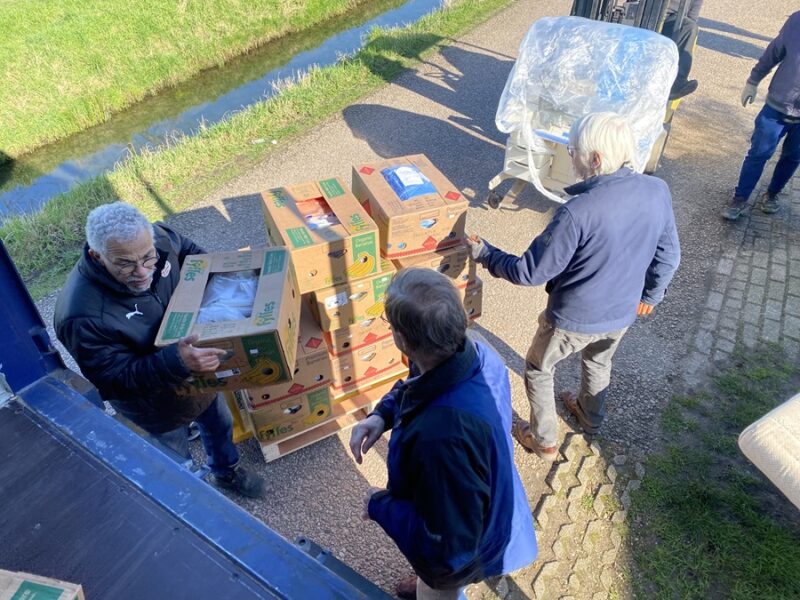 Vrijwilligers helpen met het inladen van de spullen voor Suriname. [Foto: Will van Rhee]