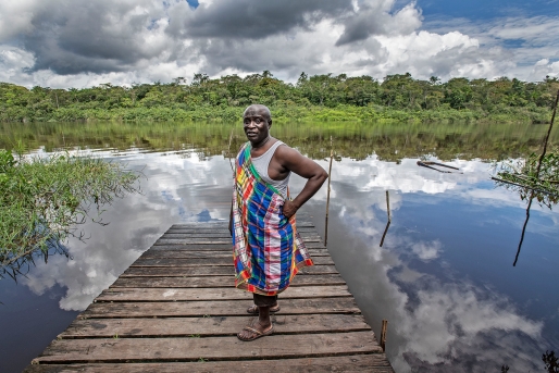 Kenneth Lazo staat op de steiger in de Saramaccarivier, lange tijd de enige verbinding van het dorp Santigron met de buitenwereld. Foto Guus Dubbelman