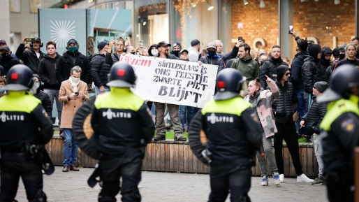 De ME houdt de grote groep tegendemonstranten op afstand ANP